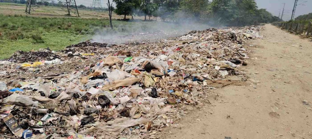 नियमों को धता बताकर आबादी के पास जलाया जा रहा कूड़ा, सांस लेना हुआ दूभर।